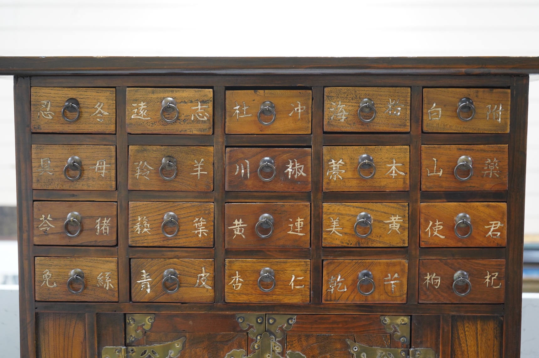 A Korean brass mounted chest with fitted drawers, decorated with calligraphy, 64cm high